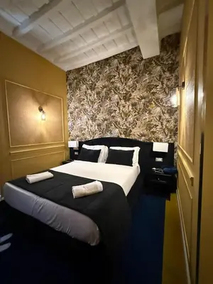 a bedroom with a large bed with two towels on it at Relais Fontana Di Trevi Hotel in Rome