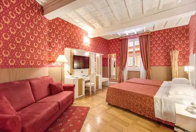 a hotel room with a bed and a couch at Relais Fontana Di Trevi Hotel in Rome