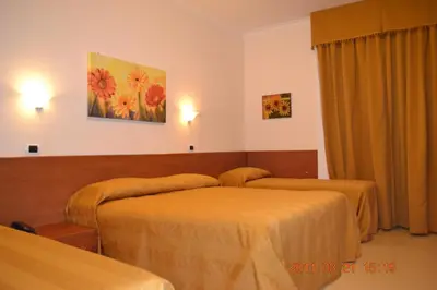 a hotel room with two beds and a painting on the wall at Hotel Everest in Rome