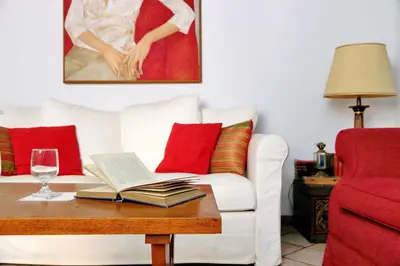 a living room with a table with a book and a glass of wine at Sangallo Charme in Rome