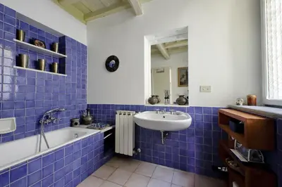 a blue tiled bathroom with a sink and a tub at Sangallo Charme in Rome