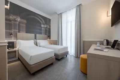 a hotel room with two beds and a flat screen tv at Hotel Astoria Garden in Rome