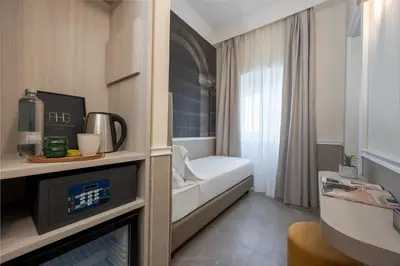 a bathroom with a walk in shower next to a bed at Hotel Astoria Garden in Rome