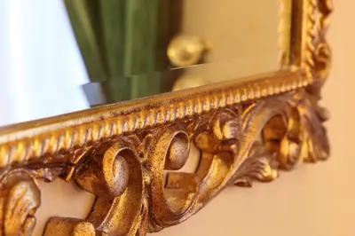 an ornate gold mirror hanging on a wall at Hotel Serena srl in Rome