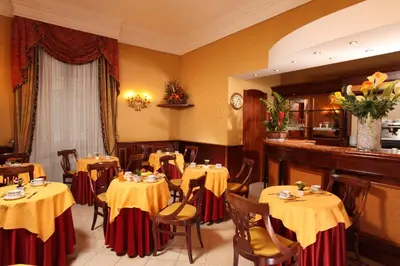 a restaurant with tables with yellow and red table cloths at Hotel Serena srl in Rome