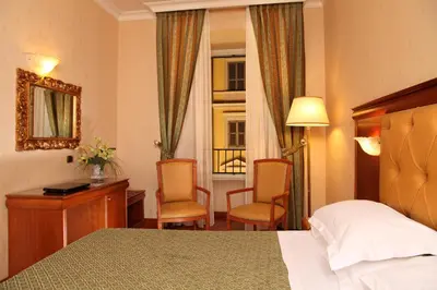 a hotel room with a bed and a desk and chairs at Hotel Serena srl in Rome