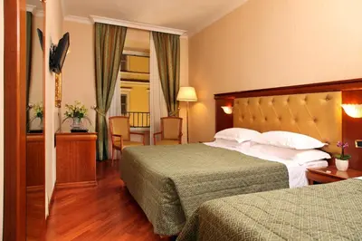 a hotel room with two beds and a mirror at Hotel Serena srl in Rome