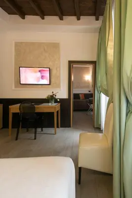 a room with a bed and a desk and a table at Duca d'Alba Hotel - Chateaux & Hotels Collection in Rome