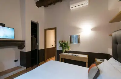 a bedroom with a bed and a desk and a television at Duca d'Alba Hotel - Chateaux & Hotels Collection in Rome