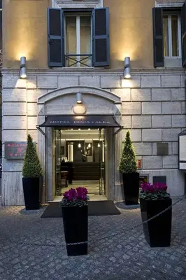 a building with two potted plants in front of it at Duca d'Alba Hotel - Chateaux & Hotels Collection in Rome