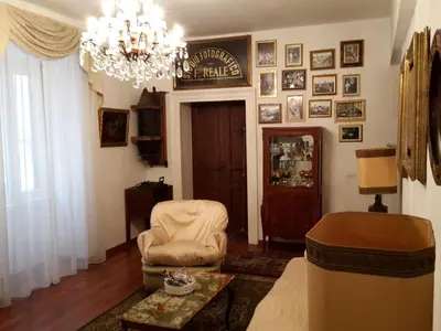 a living room with a chandelier and a chair at Suite Argentina in Rome