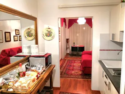 a kitchen and a living room with a red couch at Suite Argentina in Rome