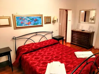 a bedroom with a red bed and a dresser at Suite Argentina in Rome