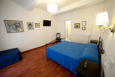 a bedroom with a blue bed and a wooden floor at Suite Argentina in Rome