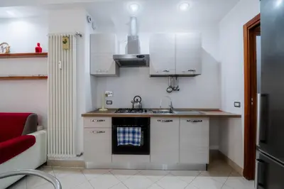 a small kitchen with white cabinets and a sink at La Casa dei Sogni di Serena in Rome