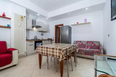 a kitchen and living room with a table and a couch at La Casa dei Sogni di Serena in Rome
