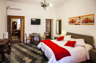 a bedroom with a bed and a table and a tv at La Dolce Vita Roma in Rome