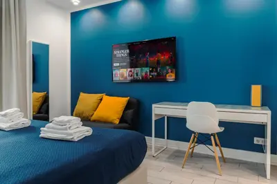 a blue bedroom with a bed and a desk at Guesthouse Sant'Angelo in Rome