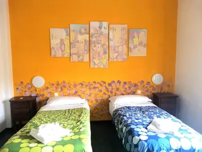 two beds in a room with an orange wall at My Vatican House in Rome