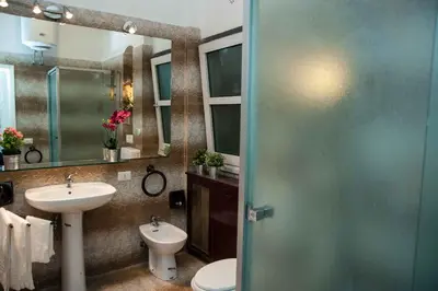 a bathroom with a sink and a toilet and a mirror at My Vatican House in Rome