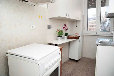 a small white kitchen with a sink and a stove at My Vatican House in Rome
