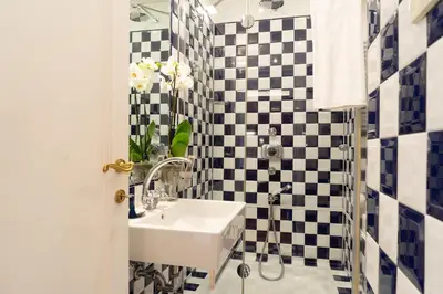 a bathroom with black and white checkered tiles at Babuino 79 in Rome