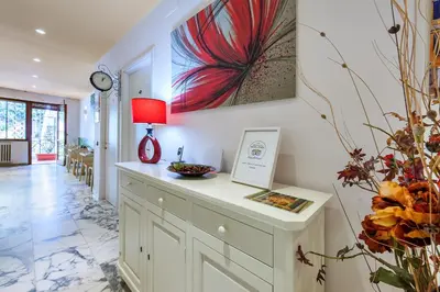 a kitchen with a counter with a red lamp and flowers at L'Oasi Verde a San Pietro apartment in Rome