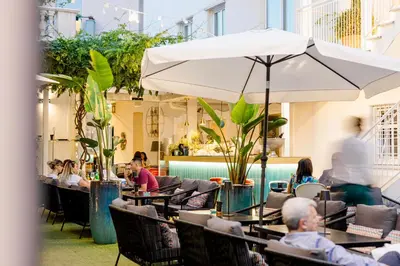 people sitting at tables in a restaurant with an umbrella at Villa Zaccardi in Rome