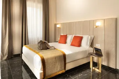 a hotel room with a large white bed with orange pillows at Villa Zaccardi in Rome