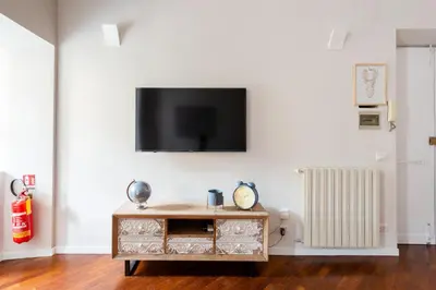 a living room with a tv on a white wall at SuityRHome RioneMonti56 in Rome