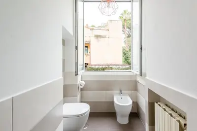 a bathroom with a toilet and a window at SuityRHome RioneMonti56 in Rome