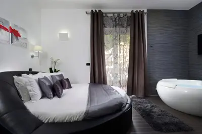 a bedroom with a large bed and a bath tub at Gregorio VII Luxury Suites in Rome