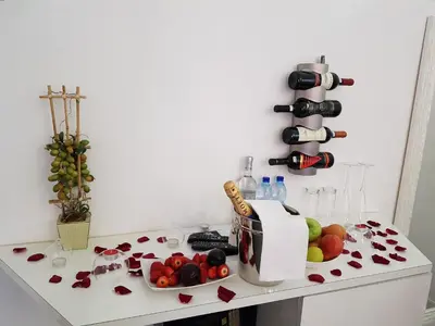 a white counter with a bunch of fruit and wine bottles at Gregorio VII Luxury Suites in Rome