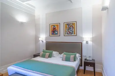 a bedroom with a bed and two pictures on the wall at Internazionale Domus in Rome