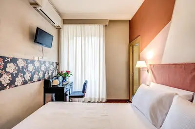 a hotel room with a bed and a desk at Boutique Hotel Galatea in Rome