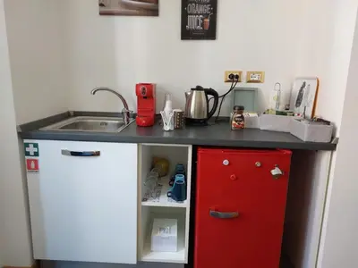 a kitchen with a sink and a red refrigerator at B&B Gaudium Colosseo in Rome