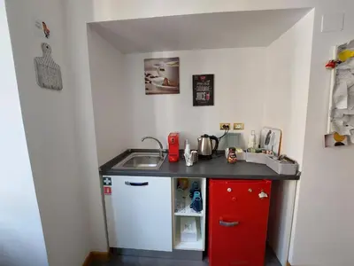 a small kitchen with a sink and a red cabinet at B&B Gaudium Colosseo in Rome