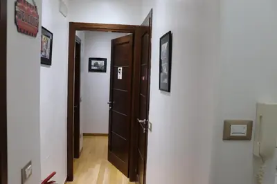 a hallway with an open door and pictures on the walls at B&B Gaudium Colosseo in Rome