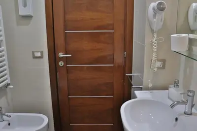 a bathroom with a wooden door next to a sink at B&B Gaudium Colosseo in Rome