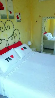 a bedroom with a bed with white sheets and a mirror at Gaia's Room B&B in Rome