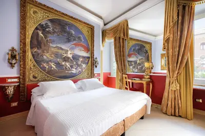 a bedroom with a large painting above a bed at Romanico Palace Luxury Hotel & SPA in Rome