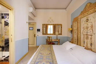 a bedroom with a large bed and a mirror at Romanico Palace Luxury Hotel & SPA in Rome