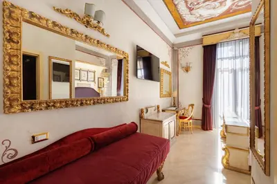 a living room with a red couch and a mirror at Romanico Palace Luxury Hotel & SPA in Rome