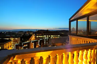 a view of a city at night from a balcony at Romanico Palace Luxury Hotel & SPA in Rome