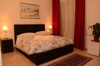 a bedroom with a bed with two pillows and red curtains at Vatican Dream in Rome