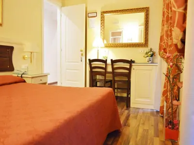 a hotel room with a bed and a table with chairs at Residenza Domiziano in Rome