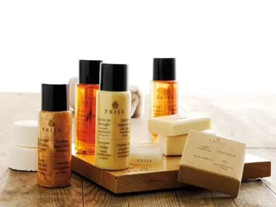 a group of four bottles of moisturizers on a wooden table at Residenza Domiziano in Rome