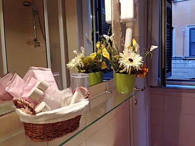 a bathroom counter with two baskets of flowers and a mirror at Residenza Domiziano in Rome