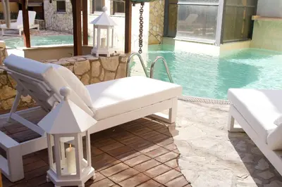 a pool with a white reclining chair next to a swimming pool at The Strand Hotel in Rome