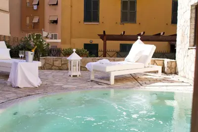 a pool with a couch and a chair next to a building at The Strand Hotel in Rome